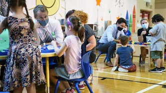 Minister O’Regan Jr and PM Trudeau sit at small tables with children