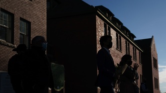 Ombres de personnes sur des immeubles de briques dans la faible lueur du soleil