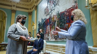 Minister Hutchings holds a bible while being sworn in