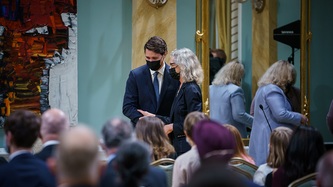 La ministre Murray parle au PM Trudeau à l'avant de la salle