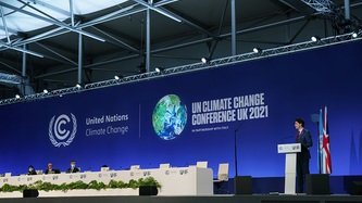 Prime Minister Justin Trudeau stands a podium with a conference banner behind him