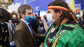 Minister Steven Guilbeault looks at a man in a crowd of people