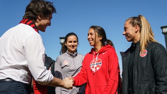 Prime Minister Trudeau shakes hand with a woman from soccer team