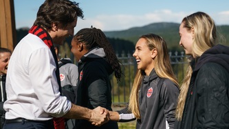 Prime Minister Trudeau shakes hand with a woman from soccer team