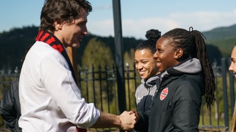 Prime Minister Trudeau shakes hand with a woman from soccer team