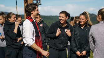 Le premier ministre Trudeau serre la main d’une femme de l’équipe de soccer 