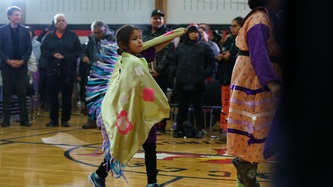 Une fillette effectue une danse au centre de la pièce