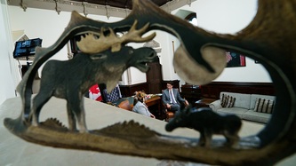 Vue du PM Trudeau et de la cheffe RoseAnne Archibald à travers un objet décoratif