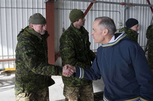 Prime Minister Carney visits Nunavut and shakes hands with a member of the Canadian Armed Forces.