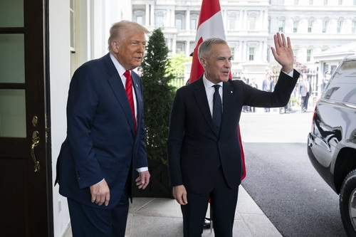 Prime Minister Carney waves as he arrives and stands outside the White House with President Trump.