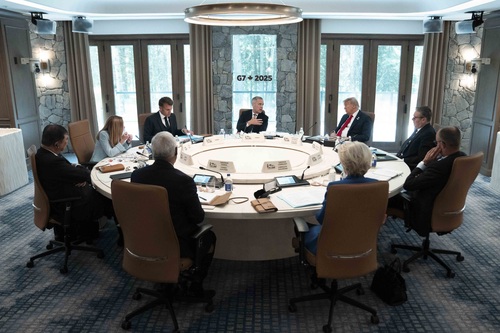 Prime Minister Carney is seated at a round table and speaking with G7 and world leaders during a G7 working session.