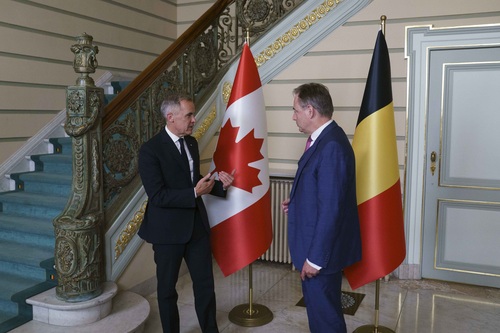 Prime Minister Mark Carney is standing and speaking with Prime Minister Bart De Wever in Brussels.
