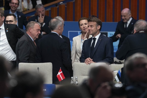 Prime Minister Carney is standing and talking with President Macron and other world leaders at the NATO Summit.