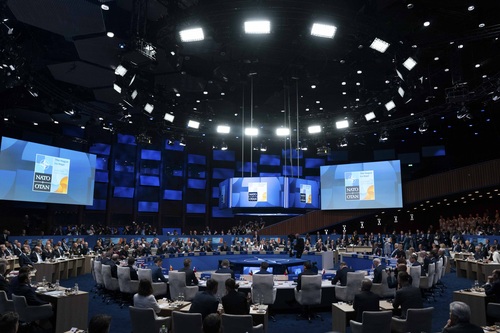 Room featuring all members at the round table of the NATO Summit.