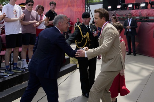 Prime Minister Mark Carney shakes hands with Ryan Reynolds at the national Canada Day ceremony.