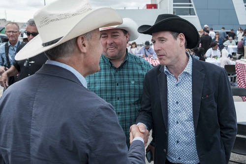 Prime Minister Carney speaking with a man at the Calgary Stampede pancake breakfast.
