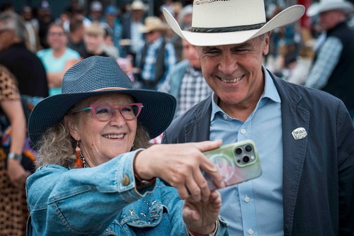 Prime Minister Carney taking a selfie with a woman at the Calgary Stampede pancake breakfast.