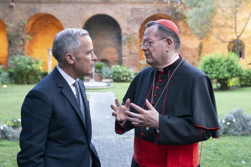 Prime Minister Mark Carney speaking with a priest at the Apostolic Palace.