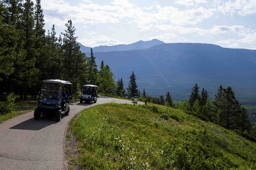 Prime Minister Mark Carney and members of staff riding in golf carts as they leave the 2025 G7 Leaders’ Summit. 