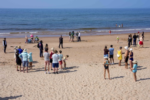 Prime Minister Carney, Parks Canada employees and other visitors at Greenwich Beach in Prince Edward Island National Park.