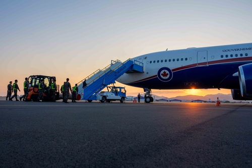 Du personnel militaire de la République de Corée se prépare à dérouler un tapis rouge près de l’avion du gouvernement du C...