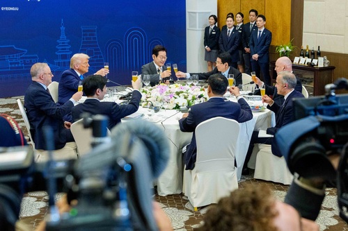 Prime Minister Mark Carney and other world leaders raise their glasses for a toast during a working dinner hosted by the P...