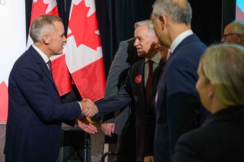 Prime Minister Mark Carney shakes hands with a man before delivering remarks related to Budget 2025 at the Canadian Club T...