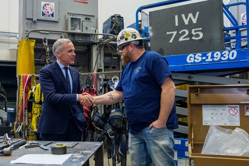 Le premier ministre Mark Carney serre la main d’un travailleur lors de sa visite pour rencontrer les membres de la section...