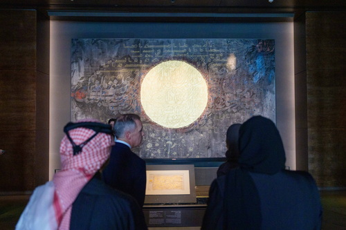 Le premier ministre Mark Carney observe une œuvre calligraphique illuminée en compagnie de ses hôtes et d’invités lors d’u...